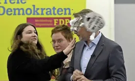 German Former Minister Attacked with Shaving Foam by Woman During Campaign Event